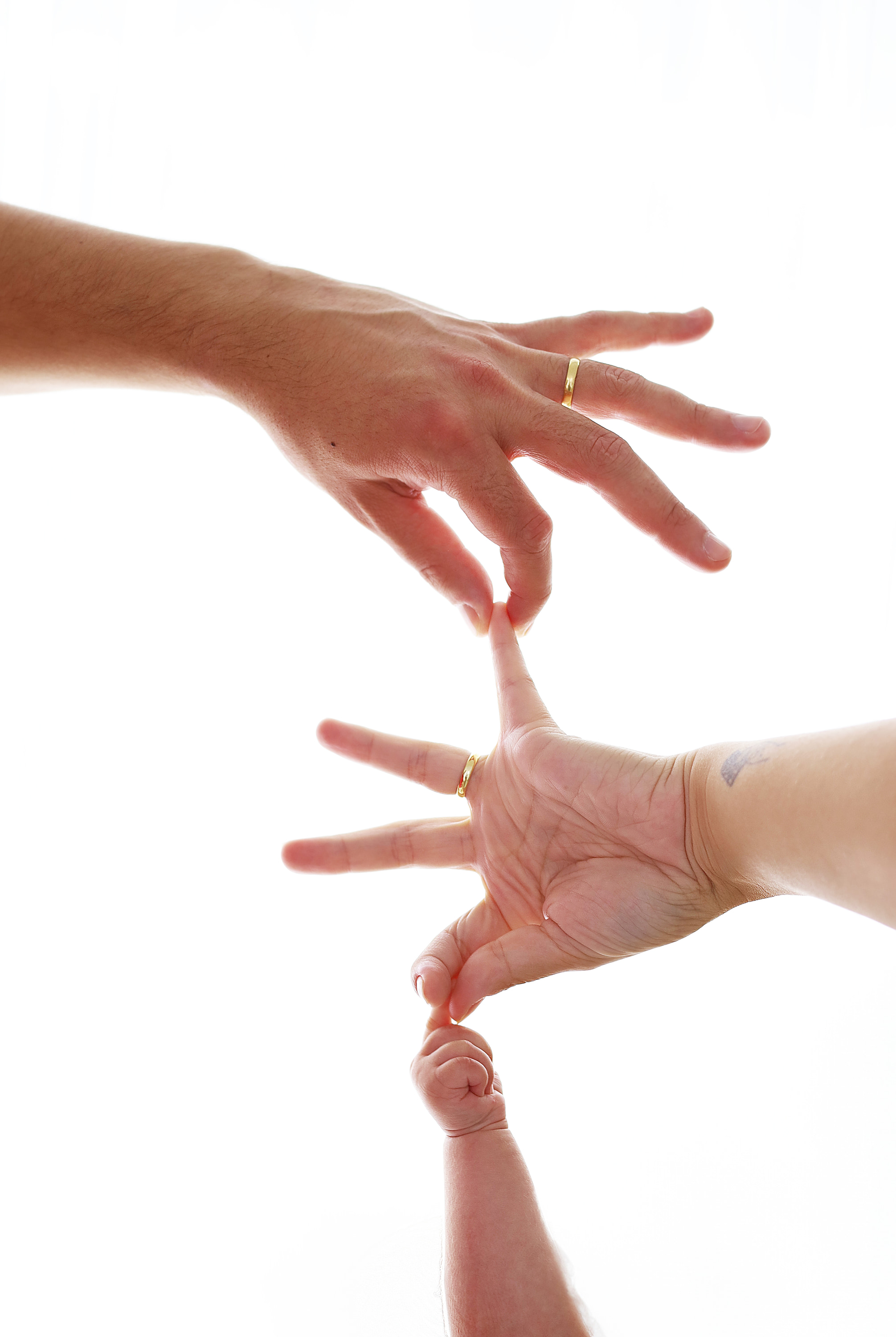 Mãos da mãe, do pai e do bebê unidas em um gesto de conexão